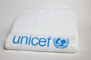 S5001006 Plastic carrier bag, with print, sealable with interlock seal, A4 exercise book size, pack of 20 Technical Specifications: Carrier bag, white, polyethylene, self sealing with interlock seal type closure on 1 short side, securely sealed along the 2 long sides with a cleanly punched handle suitable for carrying by children. Dimensions: active length (length below the base of the seal) of 350 mm, length above the top of the seal of 80 mm, width of 282 mm and thickness of 0.15 mm (150 microns). The seals on the bag must be secure and strong enough to carry up to 1000g of school materials. Books of A4 size should be easily put into the bag, sealed, and removed. The UNICEF brand (the word 'Unicef' in lowercase (small) letters, plus the mother and child emblem) should be clearly and cleanly printed in 100% cyan blue (Pantone Process Cyan), centred, on one side of the bag. Part of Early Childhood Development Kit (ECD) Part of the School in a box kit (SIB) School-in-a-Box