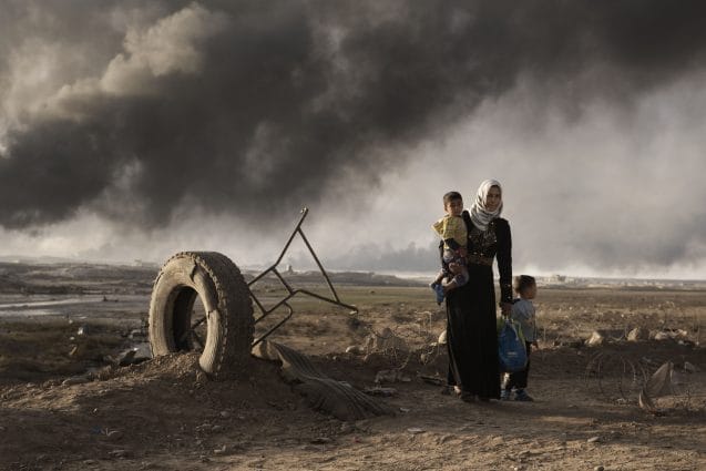 A newly displaced woman walks with two children at a check point in Qayyara, south of Mosul on October 31, 2016. On 17 November 2016, with one month of intensified military operations to retake the city of Mosul, tens of thousands of families in newly retaken areas urgently require life-saving assistance and the humanitarian community in Iraq faces a massive scope of need.  Nearly 59,000 people have been displaced, about 26,000 of them children. In support of the Government of Iraq, the United Nations and non-governmental organizations (NGOs) have begun to provide assistance to displaced and resident families in newly retaken areas. More than 40,000 displaced people have found shelter in formal camps in three governorates prepared and managed by the Government, the United Nations and national and international NGOs. More than half of the displaced people are women, girls, and female headed households who often are survivors of sexual and other human rights abuses.  More than 13,000 displaced people have been taken in by generous host communities or live in public facilities. More than 69,000 people have been given assistance within 48 hours of their displacement, more than 114,000 people have received food rations, more than 14,300 people have been provided with emergency health services and more than 66,000 people were provided with emergency household items and some 124,000 are receiving water, hygiene and sanitation services, including water trucking. Over 6,700 women and girls have received reproductive health consultations, including life-saving assisted deliveries. Some 1,400 sessions have been held to reach survivors of gender based violence. Shelter capacity and services in existing camps are being expanded and improved, and new emergency sites built.  More than 100 humanitarian partners are currently assisting people affected by the ongoing military operations according to the humanitarian principles of humanity, neutrality, impartiality and independe