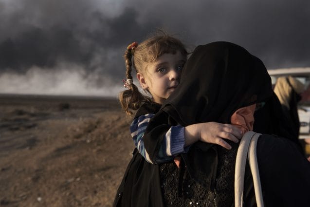 A newly displaced woman carries a child at a check point in Qayyara, south of Mosul on October 31, 2016. On 17 November 2016, with one month of intensified military operations to retake the city of Mosul, tens of thousands of families in newly retaken areas urgently require life-saving assistance and the humanitarian community in Iraq faces a massive scope of need.  Nearly 59,000 people have been displaced, about 26,000 of them children. In support of the Government of Iraq, the United Nations and non-governmental organizations (NGOs) have begun to provide assistance to displaced and resident families in newly retaken areas. More than 40,000 displaced people have found shelter in formal camps in three governorates prepared and managed by the Government, the United Nations and national and international NGOs. More than half of the displaced people are women, girls, and female headed households who often are survivors of sexual and other human rights abuses.  More than 13,000 displaced people have been taken in by generous host communities or live in public facilities. More than 69,000 people have been given assistance within 48 hours of their displacement, more than 114,000 people have received food rations, more than 14,300 people have been provided with emergency health services and more than 66,000 people were provided with emergency household items and some 124,000 are receiving water, hygiene and sanitation services, including water trucking. Over 6,700 women and girls have received reproductive health consultations, including life-saving assisted deliveries. Some 1,400 sessions have been held to reach survivors of gender based violence. Shelter capacity and services in existing camps are being expanded and improved, and new emergency sites built.  More than 100 humanitarian partners are currently assisting people affected by the ongoing military operations according to the humanitarian principles of humanity, neutrality, impartiality and independence. Wit